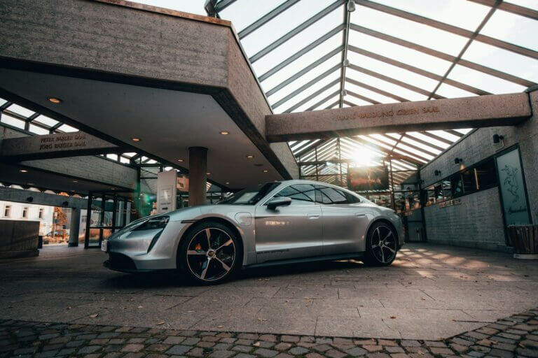 a silver sports car parked in front of a building